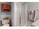 Compact bathroom with a frosted glass enclosed shower, toilet, and vintage wooden cabinet at 412 N 10Th Ave, Brighton, CO 80601