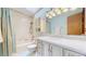 A stylish bathroom features a combined bathtub and shower, elegant vanity with lots of drawers, and a modern skylight at 412 N 10Th Ave, Brighton, CO 80601