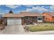 Charming brick home featuring a well-manicured front yard and an attached two-car garage, under a partly cloudy sky at 412 N 10Th Ave, Brighton, CO 80601