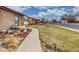 Sidewalk view leading up to a single-Gathering home, with manicured lawn, rock landscaping, and neighborhood street parking at 412 N 10Th Ave, Brighton, CO 80601