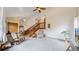 Bright living room with vaulted ceilings, a cozy rocking chair, adjacent to an open staircase and the kitchen at 412 N 10Th Ave, Brighton, CO 80601