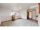The spacious living room connects to another room in the house. The walls are neutral paint with plush carpeting at 412 N 10Th Ave, Brighton, CO 80601