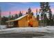 Rustic barn exterior with lights and snowy landscape at 10120 Apache Spring Dr, Conifer, CO 80433