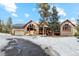 Large home with a three-car garage and beautiful landscaping at 10120 Apache Spring Dr, Conifer, CO 80433