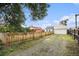 View of the backyard with a gravel driveway, wooden fence and detached garage at 150 N 7Th Ave, Brighton, CO 80601