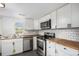 Well-lit kitchen with stainless appliances, butcher block counters, white cabinets, and subway tile backsplash at 150 N 7Th Ave, Brighton, CO 80601