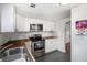 Modern kitchen design with stainless appliances, white cabinets, butcher block counters, and subway tile at 150 N 7Th Ave, Brighton, CO 80601