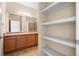 Bright bathroom featuring a dual sink vanity and built in shelving for storage at 2662 S Cathay Way # 110, Aurora, CO 80013