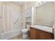 Bright bathroom featuring vanity, sink and tiled bathtub with shower and linen closet at 2662 S Cathay Way # 110, Aurora, CO 80013