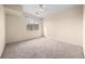 Neutral bedroom featuring a ceiling fan and a bright window overlooking the yard at 2662 S Cathay Way # 110, Aurora, CO 80013