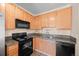 Cozy kitchen featuring wooden cabinetry, a black stove, and durable countertops at 2662 S Cathay Way # 110, Aurora, CO 80013