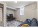 This finished basement features gray walls and floors, a window, and a dark blue couch at 2050 S Wolff St, Denver, CO 80219