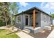 Inviting gray brick home featuring a cozy front porch with seating and well-maintained landscaping at 2050 S Wolff St, Denver, CO 80219