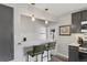 A kitchen bar features barstool seating, unique lighting, and stylish design at 2050 S Wolff St, Denver, CO 80219