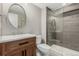 Modern bathroom features a wood vanity, glass-enclosed shower, and stylish fixtures at 8783 E Phillips Pl, Centennial, CO 80112