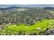 An aerial view of luxury homes surrounding a vibrant golf course, and distant mountains at 7120 Forest Ridge Cir, Castle Pines, CO 80108