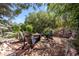 Secluded backyard area with a fire pit surrounded by Adirondack chairs and lush landscaping at 7120 Forest Ridge Cir, Castle Pines, CO 80108