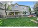 Expansive backyard features a well-maintained lawn, covered patio, hot tub, and outdoor dining area at 7120 Forest Ridge Cir, Castle Pines, CO 80108