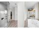 Bright bathroom featuring a glass shower, soaking tub, dual vanities and elegant wood tile flooring at 7120 Forest Ridge Cir, Castle Pines, CO 80108