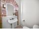 A charming powder room includes a unique sink and an arch-shaped mirror with sconces at 7120 Forest Ridge Cir, Castle Pines, CO 80108