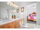 Bright bathroom boasting dual sinks, wood cabinetry and a connecting door to an adjacent bedroom at 7120 Forest Ridge Cir, Castle Pines, CO 80108