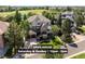 Inviting home featuring a stone facade, a private balcony, an attached garage, and mature landscaping at 7120 Forest Ridge Cir, Castle Pines, CO 80108