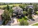 A view of the home from the street showing landscaping, a two-car garage, and trees on the property at 7120 Forest Ridge Cir, Castle Pines, CO 80108