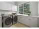 Laundry room equipped with modern washer and dryer units, ample counter space, and a window at 7120 Forest Ridge Cir, Castle Pines, CO 80108