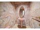 Charming powder room featuring pink fixtures, stone-like wall treatments, and elegant gold accents at 787 W Meadow Rd, Evergreen, CO 80439