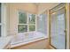 Bright soaking tub with windows showcasing serene views of nature at 787 W Meadow Rd, Evergreen, CO 80439