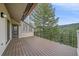 Large wooden deck with iron railing overlooking a lush forest and mountain view at 787 W Meadow Rd, Evergreen, CO 80439