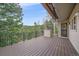 Large wooden deck with iron railing overlooking a lush forest and mountain view at 787 W Meadow Rd, Evergreen, CO 80439