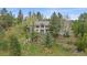 Charming home nestled among trees on a landscaped hillside featuring a stone retaining wall at 787 W Meadow Rd, Evergreen, CO 80439