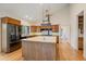 Spacious kitchen island with built-in sink and pot rack, plus stainless appliances and oak cabinetry at 787 W Meadow Rd, Evergreen, CO 80439