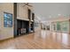 Open-concept living room with a fireplace, hardwood floors, and access to an outdoor balcony at 787 W Meadow Rd, Evergreen, CO 80439