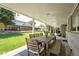Spacious covered patio with an outdoor dining table, chairs, and a bench overlooking a lush backyard at 3843 S Quince St, Denver, CO 80237