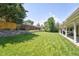 Expansive backyard featuring lush lawn, mature trees, and a charming retaining wall for outdoor enjoyment at 3843 S Quince St, Denver, CO 80237