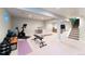 Finished basement with exercise equipment, a desk, and plenty of open space, perfect for recreation and fitness at 3843 S Quince St, Denver, CO 80237