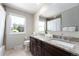 Bright bathroom featuring a double vanity with granite countertops and modern fixtures, next to a large window for natural light at 3843 S Quince St, Denver, CO 80237
