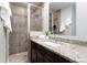 Updated bathroom featuring tiled shower with glass door and granite countertop at 3843 S Quince St, Denver, CO 80237