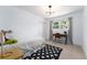 Well-lit bedroom with a modern chandelier, a desk area by the window, and a comfortable bed with storage drawers at 3843 S Quince St, Denver, CO 80237