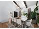 Bright dining room with a modern chandelier, wood beams, and large windows offering abundant natural light at 3843 S Quince St, Denver, CO 80237