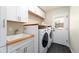 Bright laundry room featuring butcher block countertops, utility sink, and modern washer and dryer at 3843 S Quince St, Denver, CO 80237
