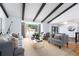 Spacious living room with exposed beams, neutral furniture, and large windows at 3843 S Quince St, Denver, CO 80237