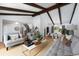 Large open-concept living room with vaulted ceilings, exposed beams, and stylish décor at 3843 S Quince St, Denver, CO 80237