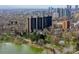 Stunning aerial view of Denver apartment buildings with lake and city skyline, showing surrounding park and walking trails at 460 S Marion Pkwy # 1351, Denver, CO 80209