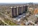 Aerial view showcasing the apartment building, surrounding trees, parking, and cityscape beyond at 460 S Marion Pkwy # 1351, Denver, CO 80209
