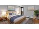 Comfortable bedroom with wood bed frame, soft lighting, balcony access, and contemporary decor at 460 S Marion Pkwy # 1351, Denver, CO 80209