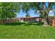 Expansive backyard showcasing a lush green lawn, mature trees, and a charming covered patio area for outdoor enjoyment at 1560 Simms St, Lakewood, CO 80215