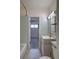 Bathroom featuring a sink, toilet, open shelving, light-blue tiling, and doorway to the bedroom at 1560 Simms St, Lakewood, CO 80215